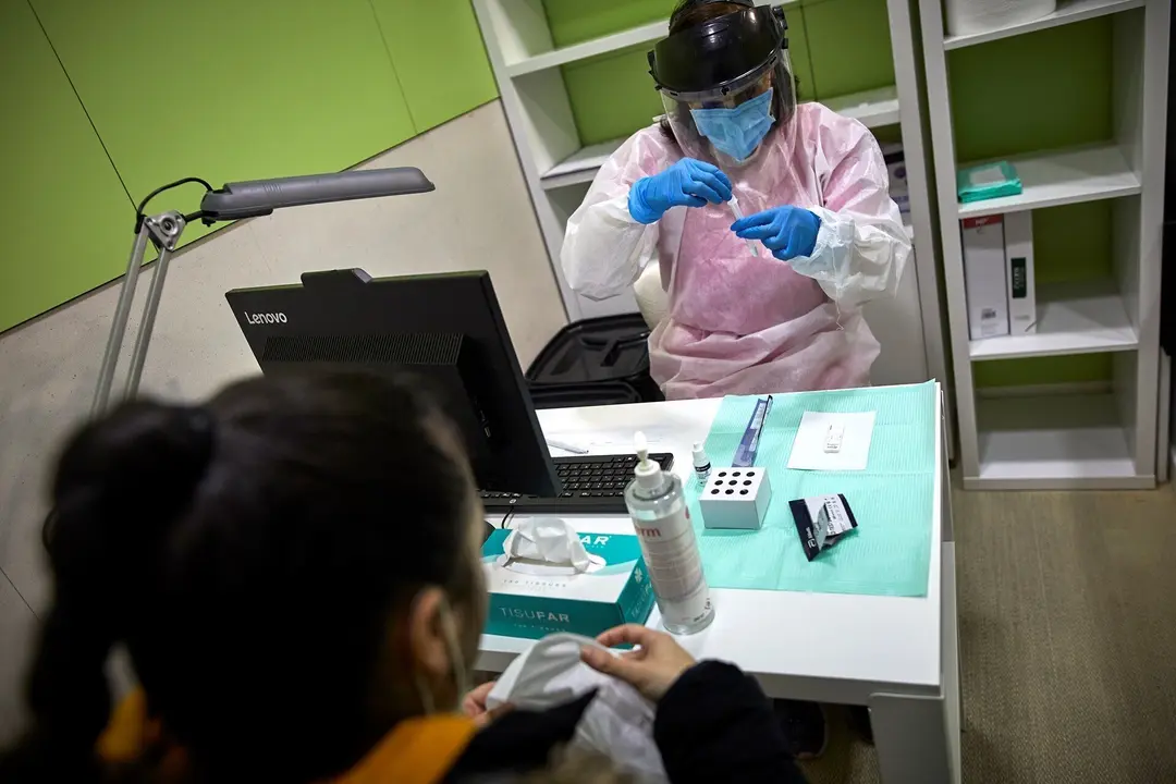 Archivo - Una farmac&eacute;utica prepara un test de ant&iacute;genos para realiz&aacute;rselo a una mujer en la Farmacia Las Gemelas en Madrid (Espa&ntilde;a), a 11 de febrero de 2021.