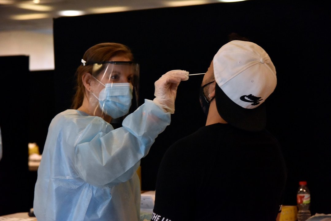 Una trabajadora sanitaria realiza un test de antígenos a un joven para acceder al primer día del festival Cruïlla, a 8 de julio de 2021, en Barcelona, Cataluña, (España).