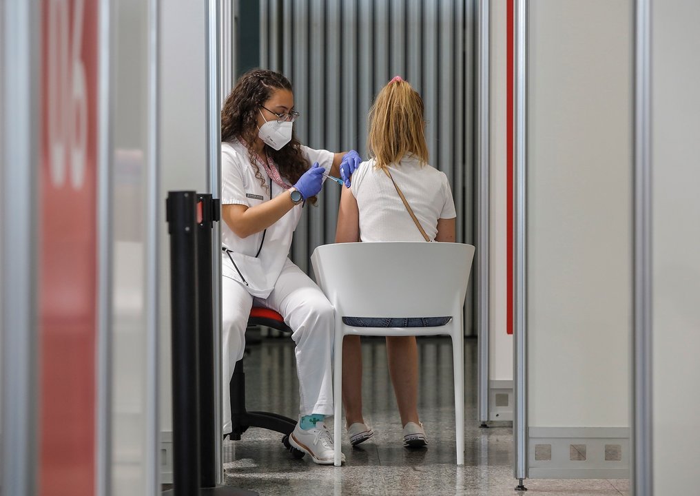 Una joven recibe la vacuna contra el Covid-19 en el dispositivo puesto en marcha en la Ciutat de les Arts i les Ciències de Valencia, a 28 de julio de 2021, en Valencia, Comunidad Valenciana, (España). Este gran punto de vacunación, uno de los puestos en 