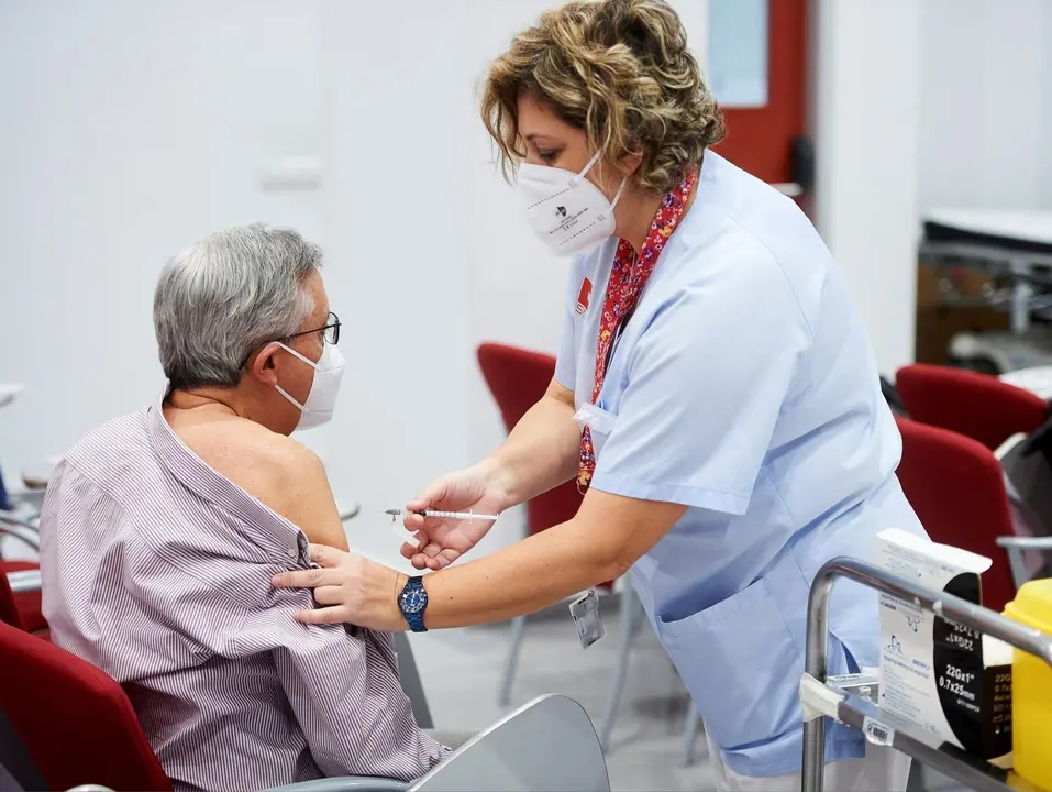 Archivo - Una trabajadora sanitaria inyecta la segunda dosis de la vacuna de Pfizer. Archivo