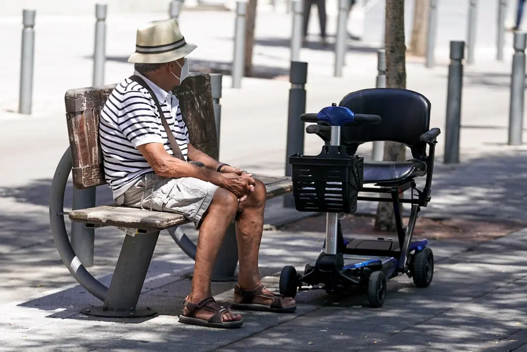 Un anciano con mascarilla sentado en un banco, a 27 de julio de 2021, en Madrid, (Espa&ntilde;a).