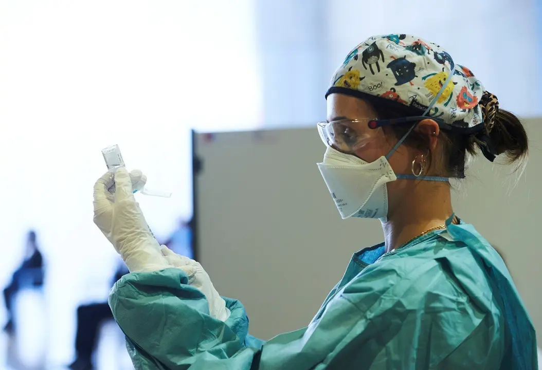 Archivo - Una profesional sanitaria sostiene un vial con la vacuna contra el Covid-19