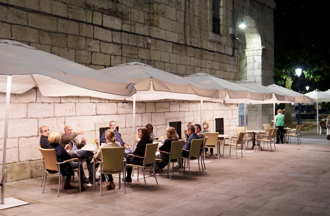 Archivo - Varias personas en una terraza de Santander, antes de su cierre a medianoche