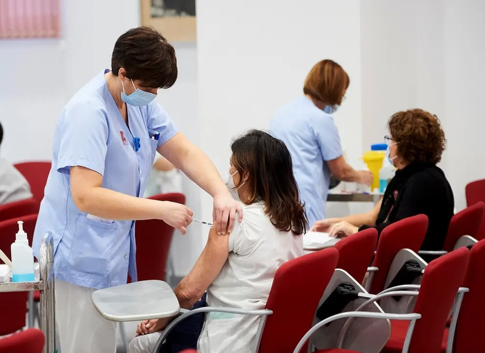 Archivo - Un trabajadora sanitaria inyecta la segunda dosis de la vacuna de Pfizer.- Archivo