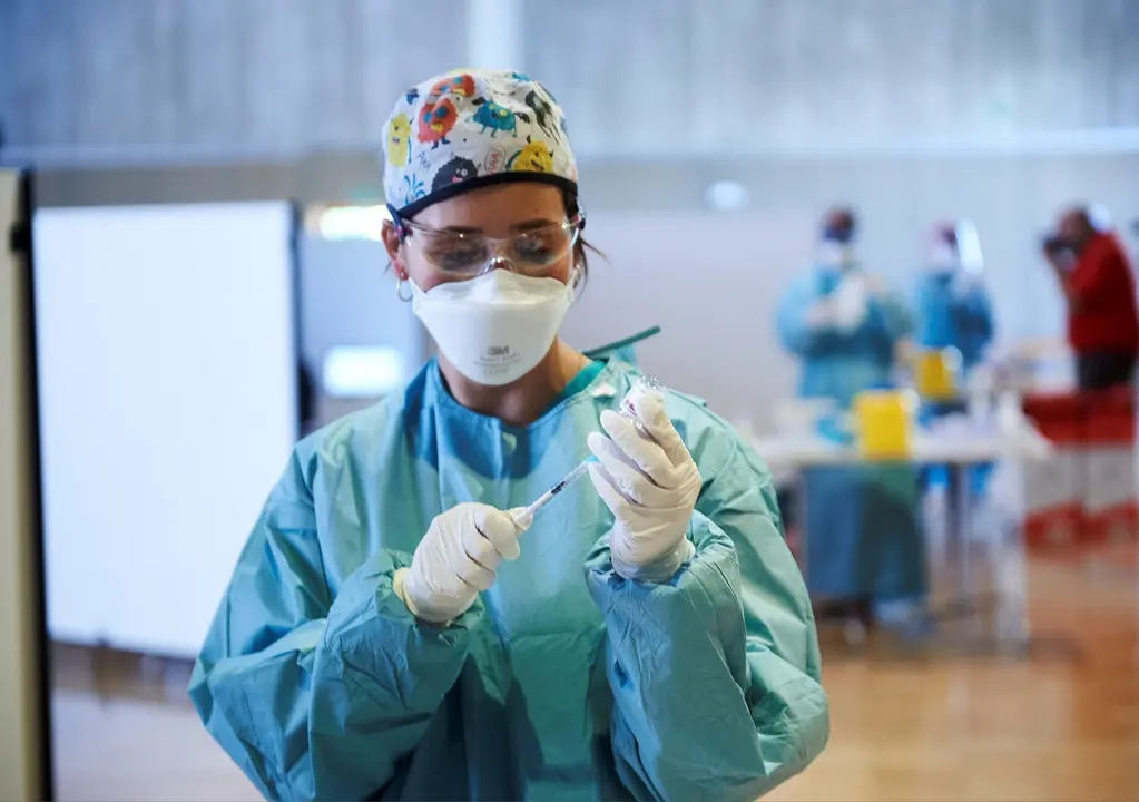 Archivo - Una profesional sanitaria sostiene un vial con la vacuna de AstraZeneca.- Archivo