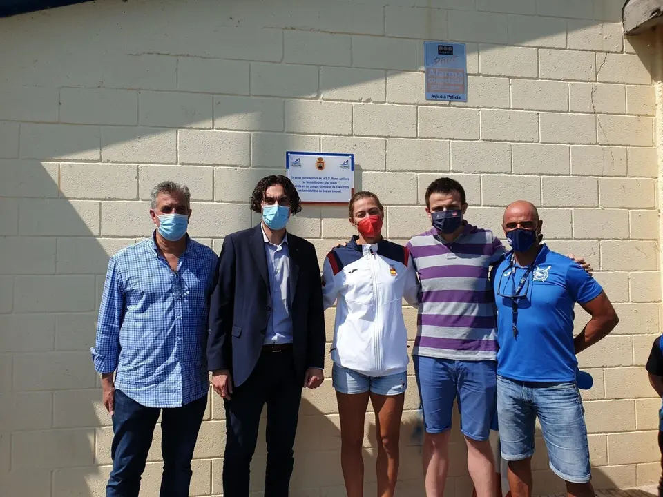Virginia D&iacute;az, con autoridades municipales, posando junto a la placa colocada en las instalaciones deportivas de la Sociedad de Remo de Astillero, en conmemoraci&oacute;n de su actuaci&oacute;n en los Juegos Ol&iacute;mpicos de Tokyo 2020
