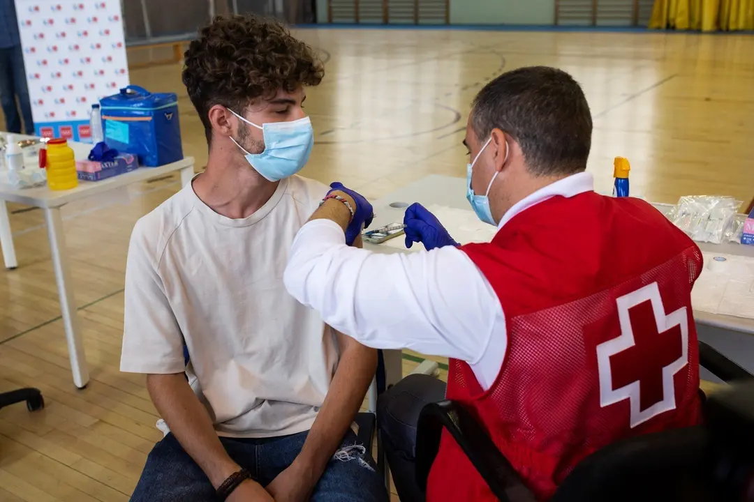 Un voluntario de Cruz Roja administra una dosis de la vacuna contra el Covid-19 a un estudiante universitario en el campus de Ciudad Universitaria, a 14 de septiembre de 2021, en Madrid, (Espa&ntilde;a). 