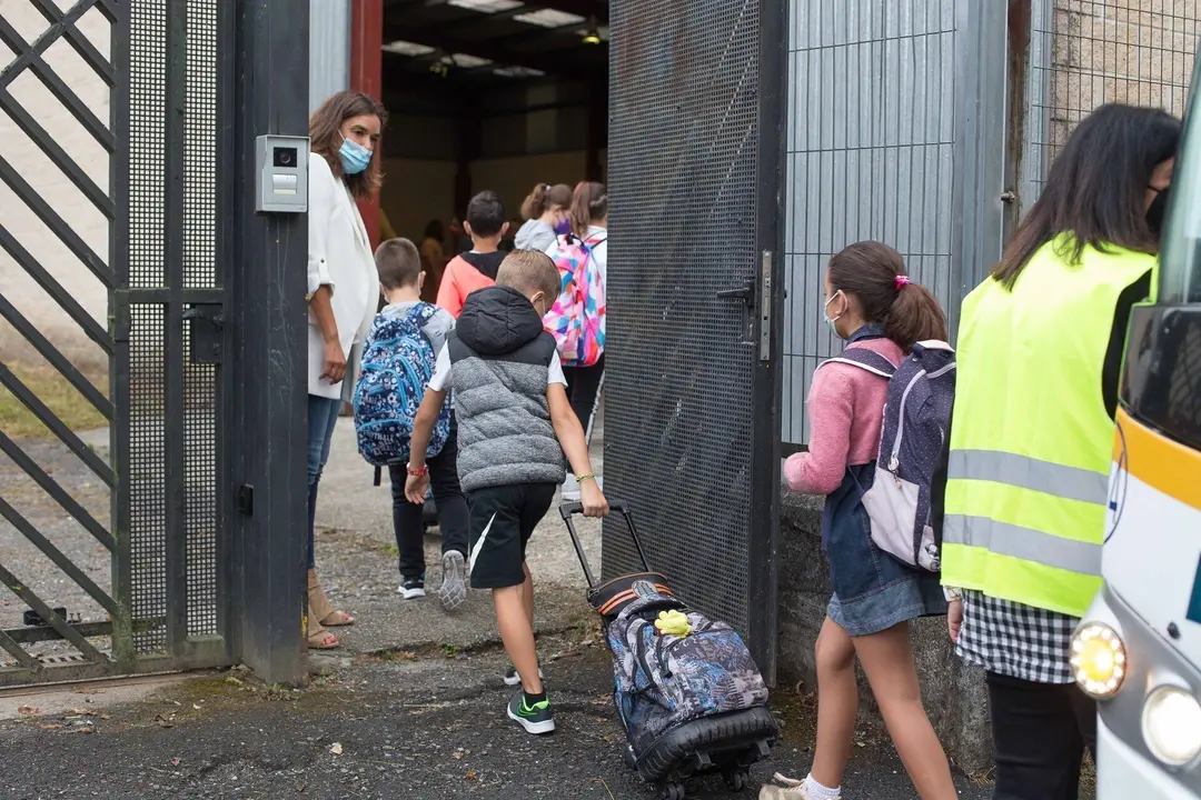 Varios ni&ntilde;os y ni&ntilde;as entrando al colegio.