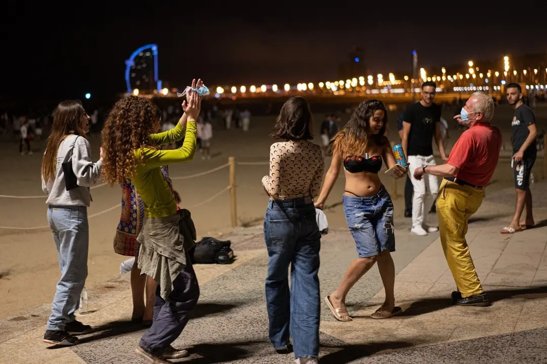 Archivo - Un grupo de chicas y un se&ntilde;or bailan a pi&eacute; de playa, a 27 de junio de 2021, en Barcelona, Catalunya (Espa&ntilde;a). Este jueves 24 de junio, en un Consejo de Ministros extraordinario, el Gobierno de Espa&ntilde;a aprob&oacute; que las mascarillas dejasen de ser obl