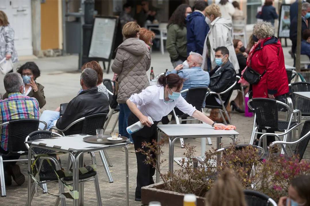 Ribadeo, Lugo. Primer dia tras el fin del Estado de Alarma en toda Espa&ntilde;a. Desde hoy domingo se puede de nuevo pasar de una Comunidad Aut&oacute;noma a otra. En la im&aacute;gen, una trabajadora limpia la mesa de una terraza de hosteler&iacute;a en la ma&ntilde;ana del domingo 9 de Mayo