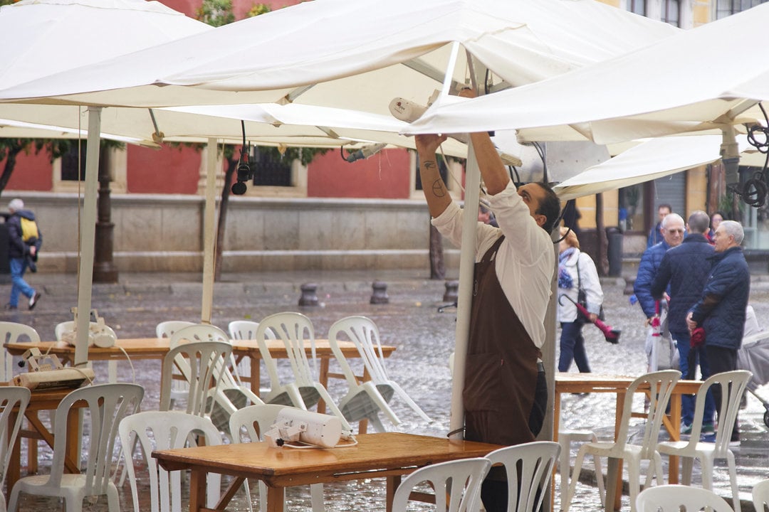 Un camarero pone los calefactores en una terraza en el puente del mes de diciembre en Sevilla, a 9 de diciembre de 2022 en Sevilla (Andalucía, España). Los comercios de la ciudad de Sevilla han tenido que ver reducido sus ingresos por las precipitaciones desde el pasado lunes.