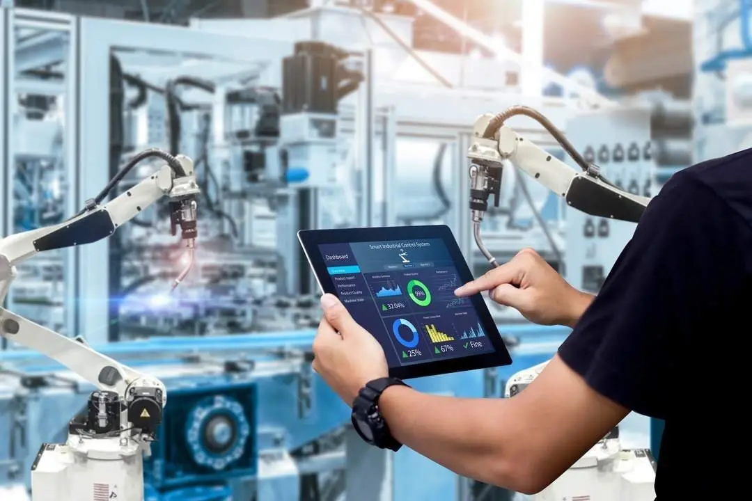 Smart industry control concept.Hands holding tablet on blurred automation machine as background