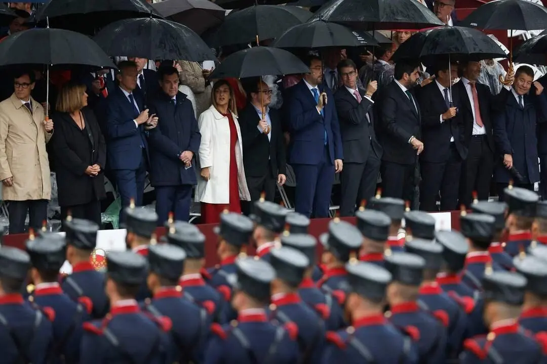 MADRID, 12/10/2024.- Los presidentes auton&oacute;micos asisten bajo la lluvia al desfile por el D&iacute;a de la Fiesta Nacional en Madrid. Un total de 4.092 efectivos de las Fuerzas Armadas, de los cuales 473 son mujeres, 85 aeronaves, 266 veh&iacute;culos motorizados y 210 caballos participar&aacute;n en la parada militar, presidida por los reyes Felipe y Letizia, acompa&ntilde;ados de la Princesa Leonor. EFE/Chema Moya