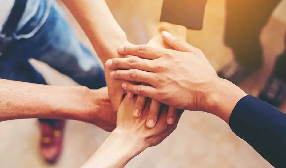 Concept of teamwork: Close-Up of hands business team showing unity with putting their hands together.