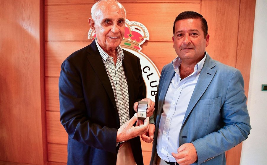 El presidente de la Fundación y vicepresidente del Racing, Pedro Ortiz, entrega a Valentín Valle la insignia