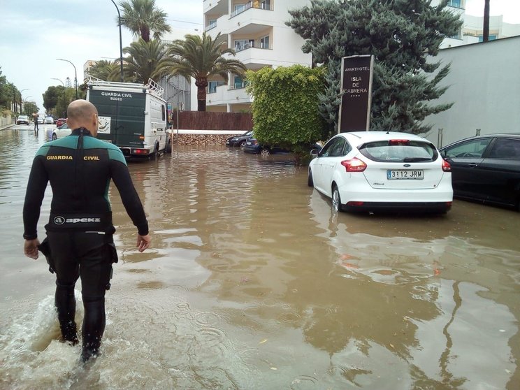 Un agent camina en una carretera afectada per una inundació sud de Mallorca.