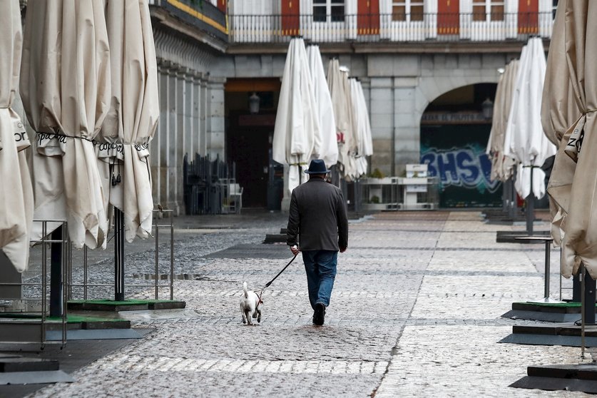 Un hombre pasea a su perro por la vac’a Plaza Mayor de Madrid durante el sexto d’a del estado de alarma por coronavirus, en Madrid (Espa–a) a 21 de marzo de 2020.