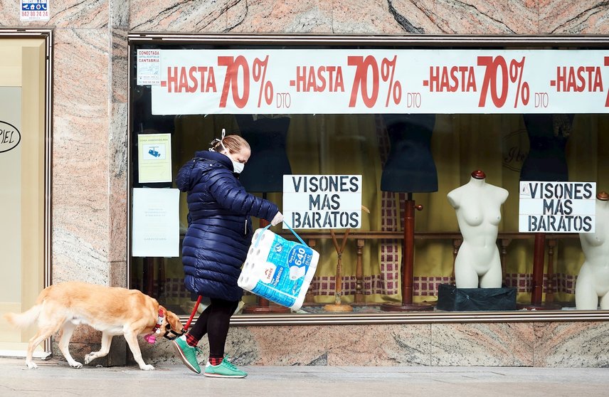 Mujer paseando frente a tienda en Santander. Archivo