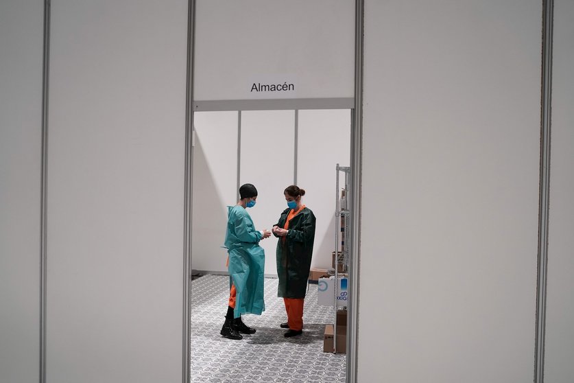 Dos trabajadores sanitarios hablan en las instalaciones del hospital de campaña instalado en IFEMA 