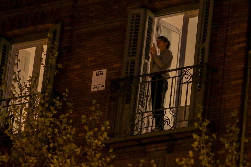 Una mujer aplaude desde su balcón por la labor que están realizando los sanitarios ante la crisis de contagios por el coronavirus, en Madrid (España), a 17 de marzo de 2020.