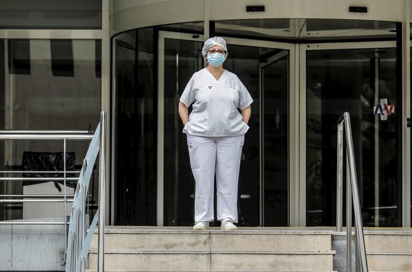 Sanitaria protegida con mascarilla y gorro durante el minuto de silencio en la entrada del Hospital Doctor Peset por la técnica de enfermería fallecida por coronavirus, en Valencia/Comunidad Valenciana (España) a 6 de abril de 2020.