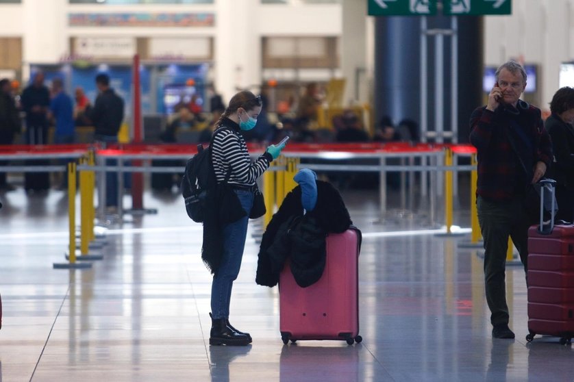 Una turista con mascarilla y guantes en el aeropuerto de Málaga este lunes 16 de marzo de 2020