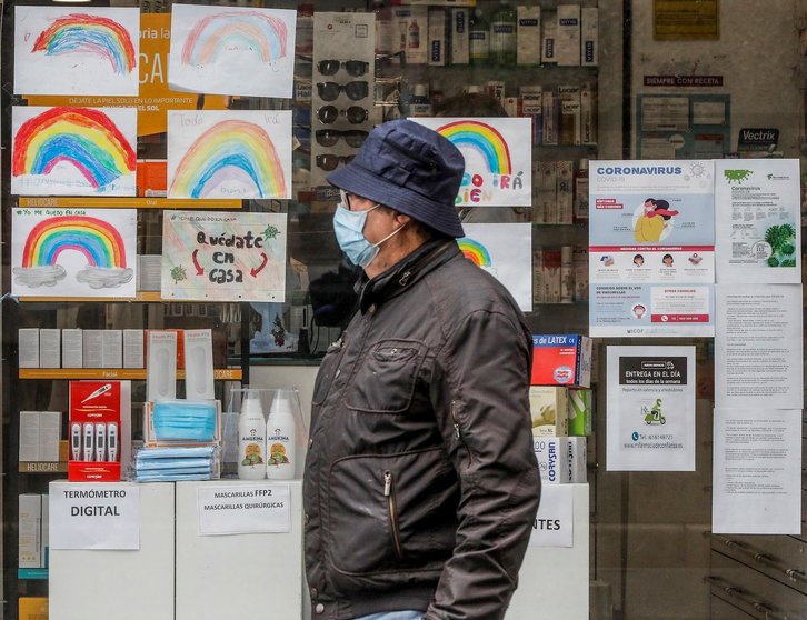 Un hombre con mascarilla pasa junto a una farmacia con dibujos infantiles en su escaparate durante el reparto de mascarillas gratuitas contra el Covid-19 a mayores de 65 años y colectivos de riesgo que ayer arrancó en la Comunitat Valenciana. Después de a
