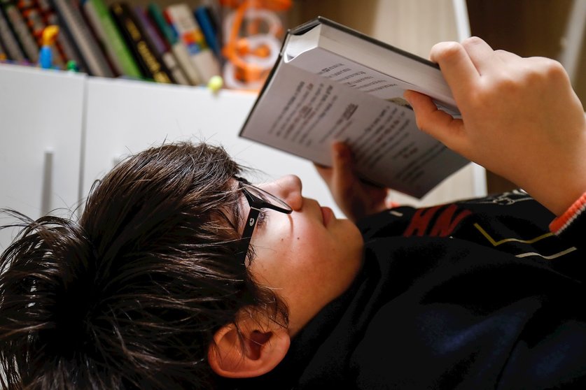 Un niño lee en su cuarto durante el confinamiento por el coronavirus, en Valdemoro/Madrid (España) a 20 de abril de 2020.