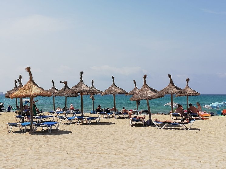 Turistas en hamacas bajo las sombrillas de la Playa de Palma.