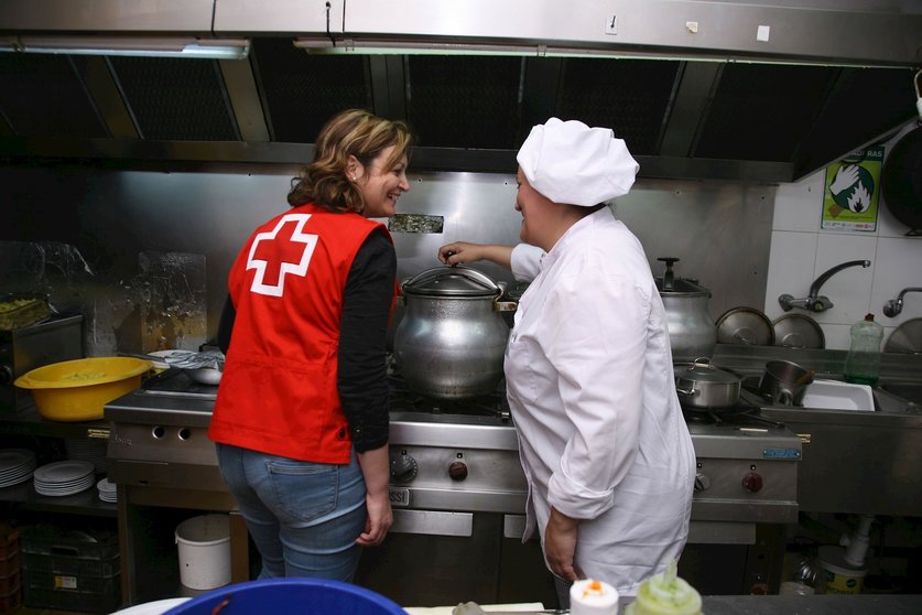 Una trabajadora de Cruz Roja junto a una cocinera