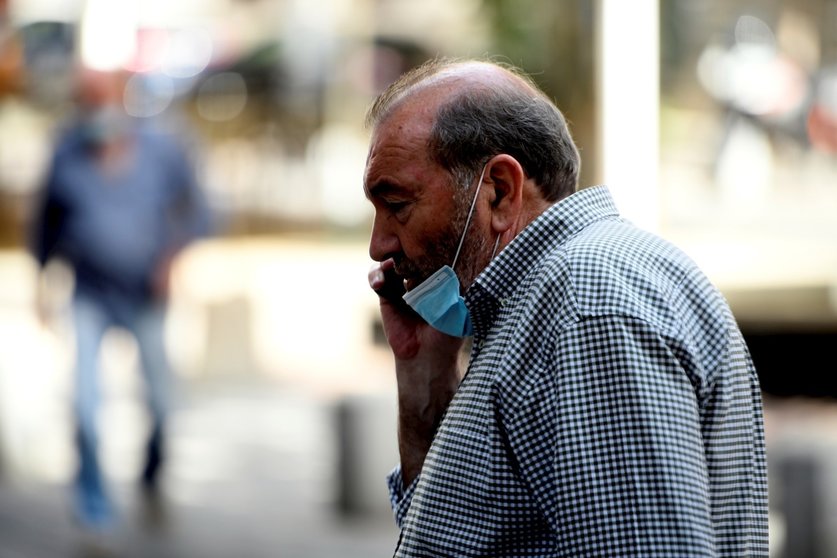 Un hombre con mascarilla habla por teléfono en la calle, en Madrid (España) a 30 de julio de 2020.