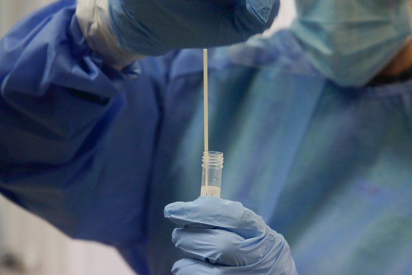 Una trabajadora sanitaria sostiene una probeta con una prueba PCR. Archivo