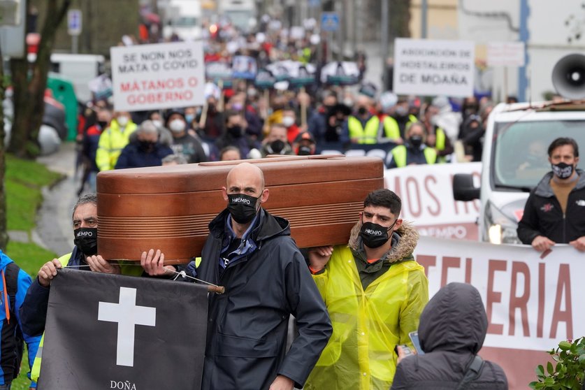 Trabajadores del sector hostelero sostienen una làpida frente a la Xunta de Galicia como signo de protesta, en Santiago de Compostela, A Coruña, Galicia, (España),  