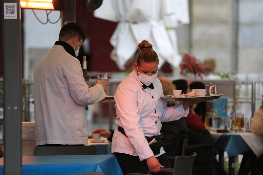 Dos camareros trabajan en la terraza de un bar en el centro de Madrid (España)
