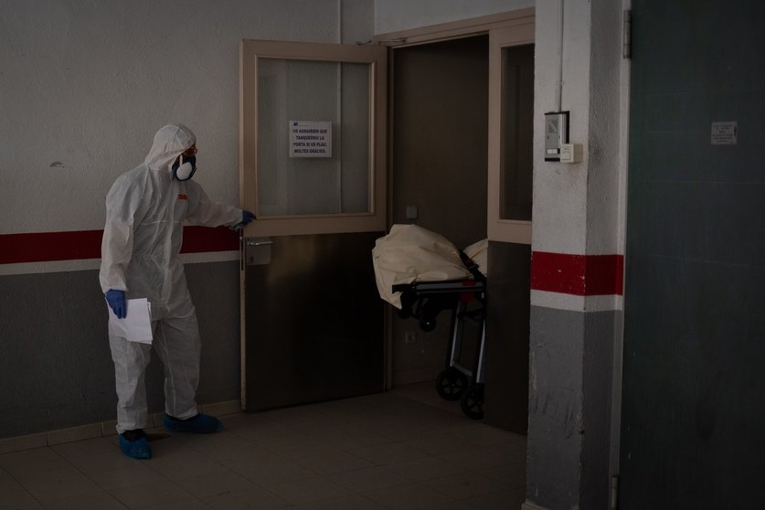 Varios operarios protegidos de los Servicios Funerarios Memora trasladan el cuerpo de una persona fallecida en una residencia de ancianos de Girona durante la pandemia.