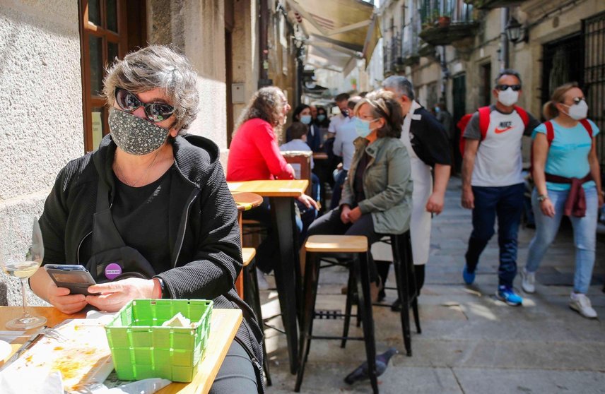 Archivo - Varias personas en una calle de terrazas de Baiona, en Vigo, Pontevedra, Galicia (España), a 28 de marzo de 2021. El subcomité clínico mantiene el nivel alto de restricciones en el concello de Baiona, lo que conlleva que la hostelería solo puede