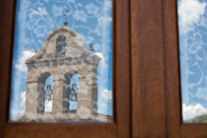 Reflejo de una iglesia en un cristal de una vivienda.
