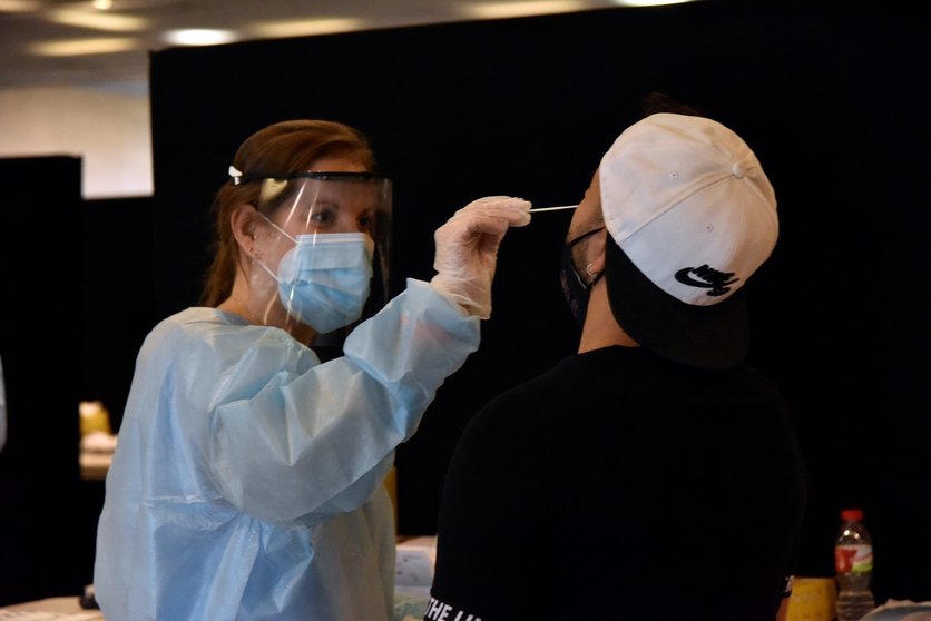 Una trabajadora sanitaria realiza un test de antígenos a un joven para acceder al primer día del festival Cruïlla,