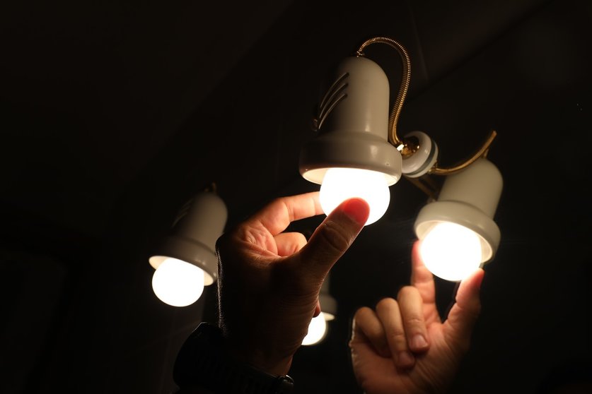 Una persona cambia la bombilla de una lámpara