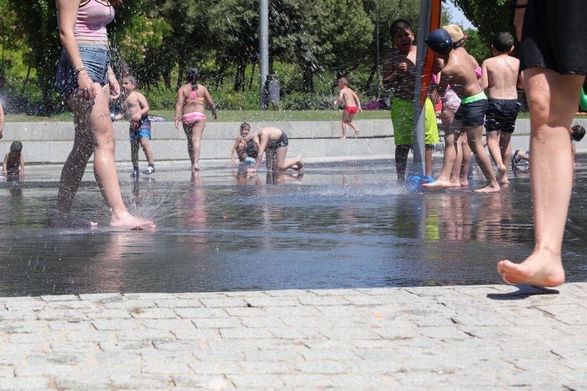 Varias personas, entre ellas niños, se refrescan en los chorros de Madrid Río un día antes de que, según la Agencia Estatal de Meteorología (AEMET), llegue a la península Ibérica y a las Islas Baleares la primera ola de calor del verano 2019.