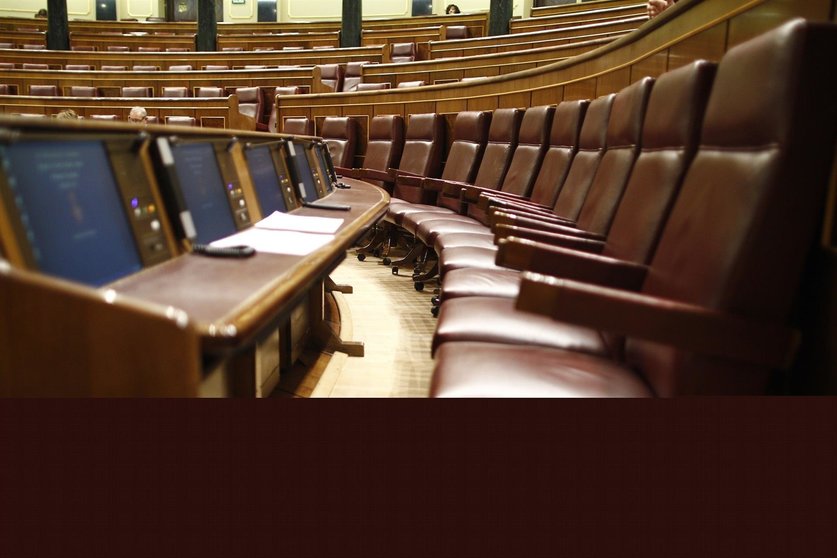 Escaños del hemiciclo del Congreso de los Diputados vacíos.
