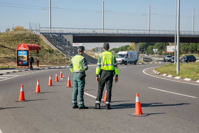 Dos agentes de la  Guardia Civil de Tráfico en medio de la carretera durante la campaña especial de la DGT de vigilancia y control de furgonetas, en el Km 0,1 de la M-511, en Madrid, a 28 de octubre de 2019.