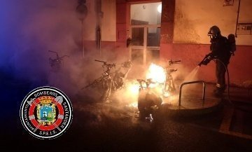 Los bomberos tratan de sofocar el incendio de las motos