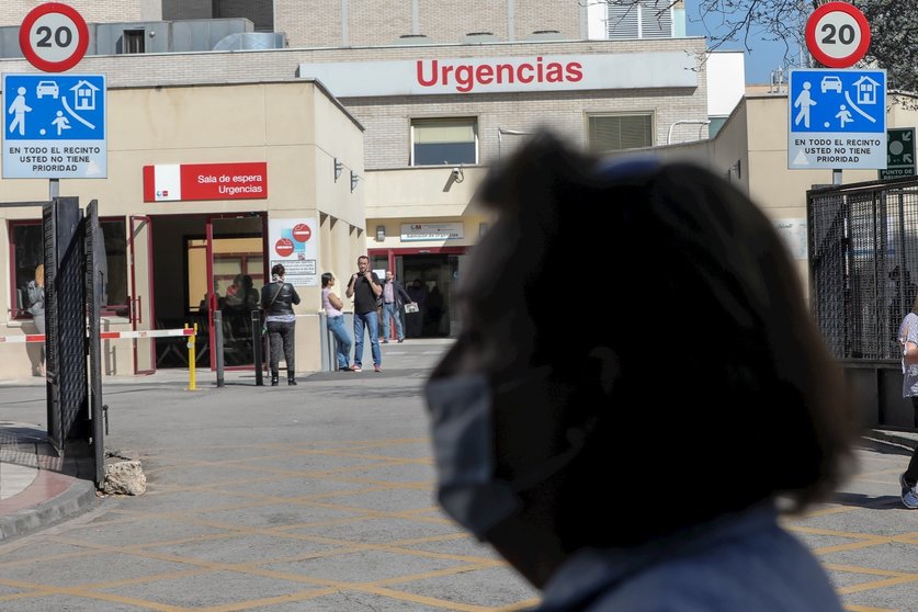 Una mujer protegida con mascarilla pasea cerca de la puerta de Urgencias del Hospital Gregorio Marañón, un día después de que el presidente del Gobierno, Pedro Sánchez, declarase el Estado de Alarma debido a la crisis del coronavirus en España, en Madrid 