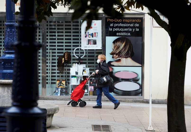 Una mujer camina por las calles de Santander con mascarilla