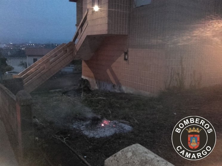 Incendio provocado por la quema de unos restos vegetales que estaban amontonados en los aledaños de una casa de la calle Luis Gómez Cagigas de Muriedas.