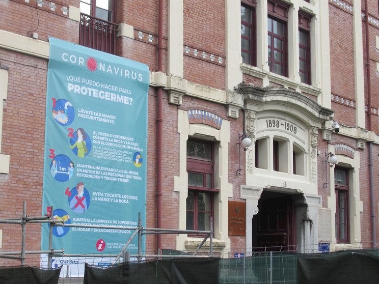 Cartel informativo sobre el coronavirus en la fachada del hospital de Basurto, en Bilbao