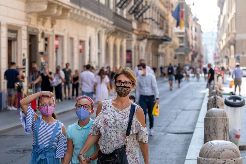 Una familia pasea con mascarilla por Roma
