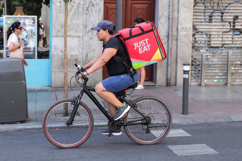 Fotografía de un repartidor de la empresa de reparto Just Eat transitando en bicicleta por una calle del centro de Madrid.