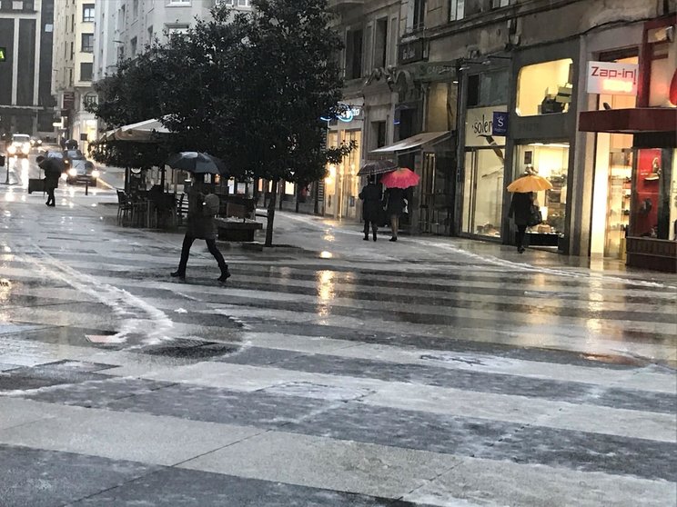 Jornada de lluvia y granizo en Santander, gente con paraguas, lluvia, frío